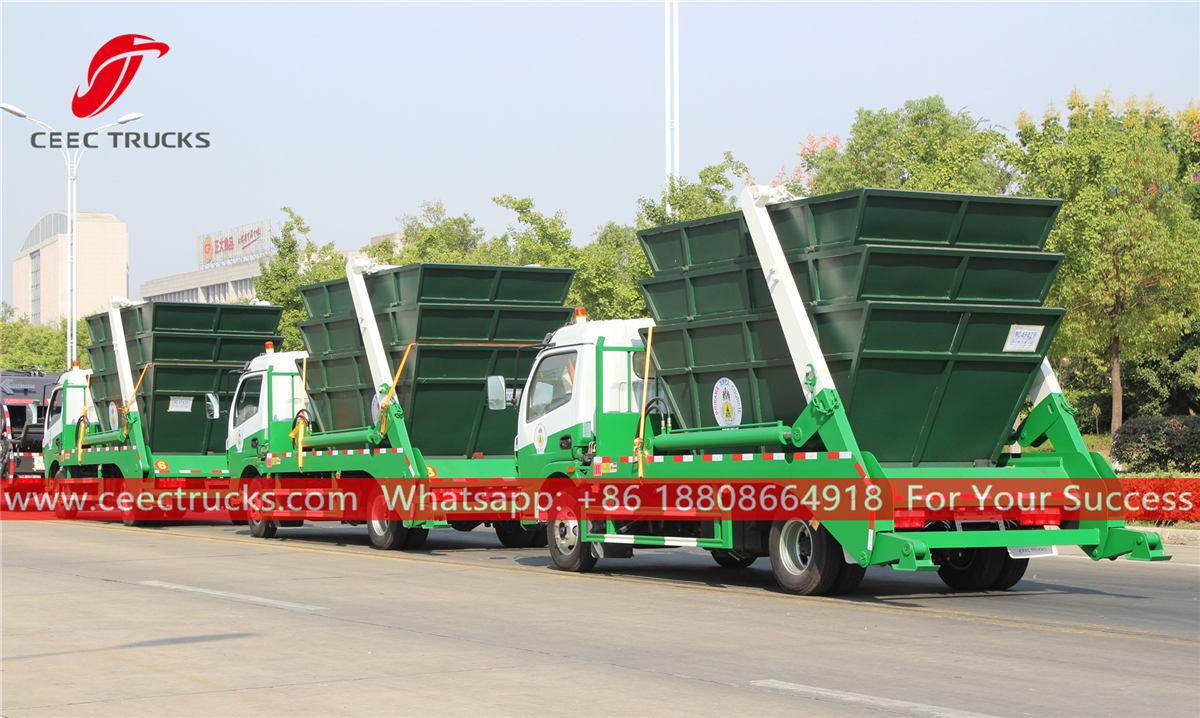 Swing arm garbage trucks with bins